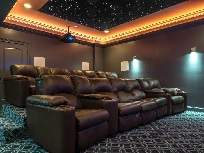 Home theater with warm cove lighting and a star ceiling above tiered seating